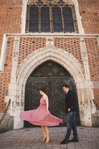华丽的新婚夫妇，新郎和新娘与粉红色的裙子，走在这座古城，克拉科夫 — 图库照片