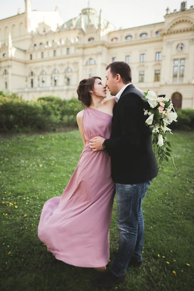 Matrimonio. Un paio. Cracovia. La sposa in un abito rosa e sposo posa sullo sfondo del teatro — Foto Stock