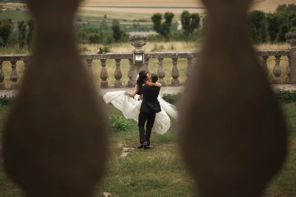 Hermosa boda romántica pareja de recién casados abrazos cerca del viejo castillo — Foto de Stock