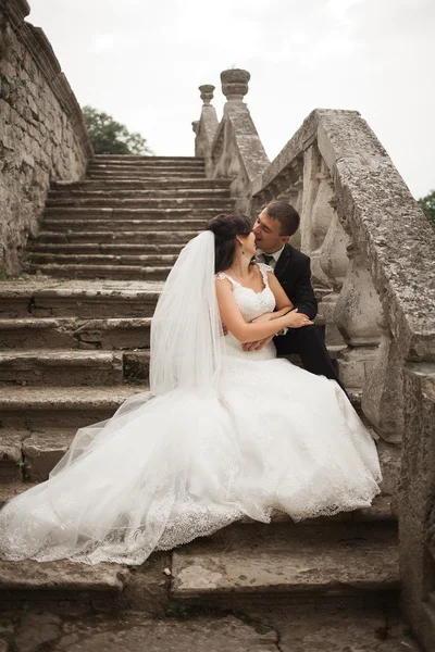 Güzel, romantik bir düğün. Yeni evliler. Eski kalenin yakınlarında sarılıyorlar. — Stok fotoğraf