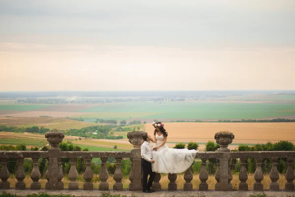 美しいロマンチックな結婚式のカップルの新婚旅行の近くに古い城抱擁 — ストック写真