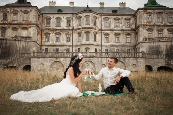 Šťastný Svatební pár objímat a líbat na pozadí starý hrad — Stock fotografie