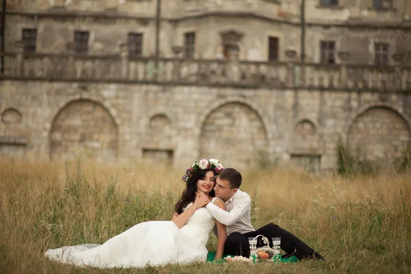 Feliz boda pareja abrazos y besos en el fondo viejo castillo — Foto de Stock