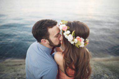 Mavi Denizi çevresinde büyük bir taş üzerinde oturan Düğün çifti