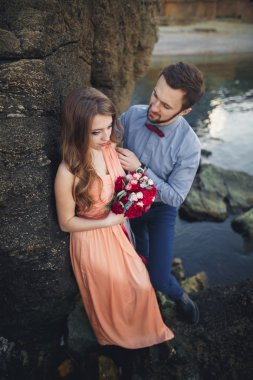 Mavi Denizi çevresinde büyük bir taş üzerinde oturan Düğün çifti