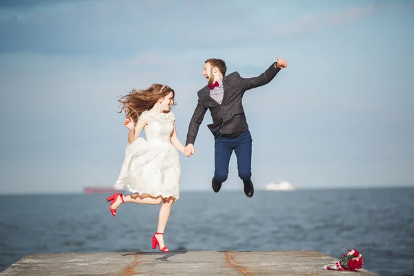 結婚式の幸せだけ結婚している若いカップルを祝う美しいビーチの夕日で楽しく、 — ストック写真