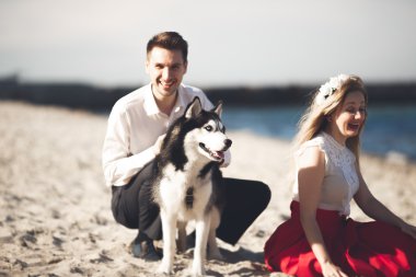 mutlu bir çift sahilde köpeklerle portresi