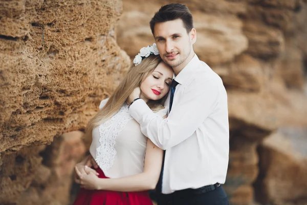 Casal amoroso romântico andando na praia com pedras e pedras — Fotografia de Stock