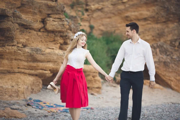 Casal amoroso romântico andando na praia com pedras e pedras — Fotografia de Stock