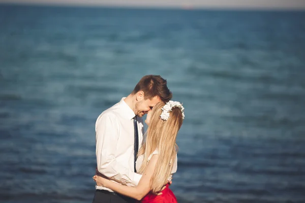 Jovem casal feliz andando na praia sorrindo segurando um ao lado do outro. História de amor — Fotografia de Stock