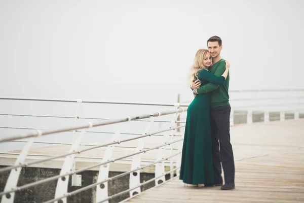 Preciosa pareja besándose y abrazándose en un muelle de mar — Foto de Stock