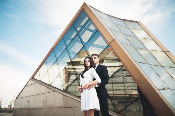 Şık sevgi dolu çift öpüşme ve yakındaki modern Binası sarılma — Stok fotoğraf
