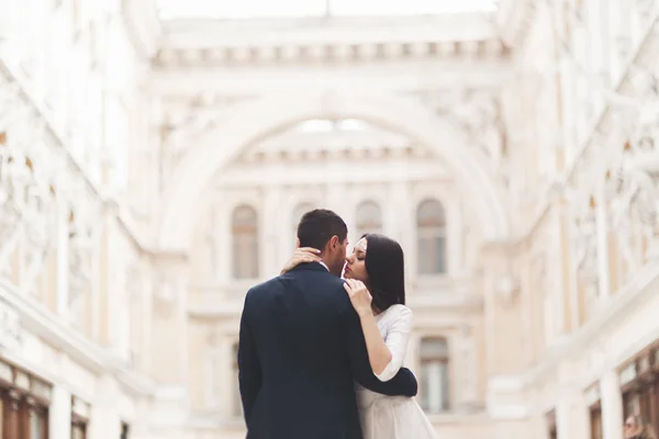 Casal de casamento bonito, noiva, noivo beijando e abraçando contra o fundo do edifício velho — Fotografia de Stock