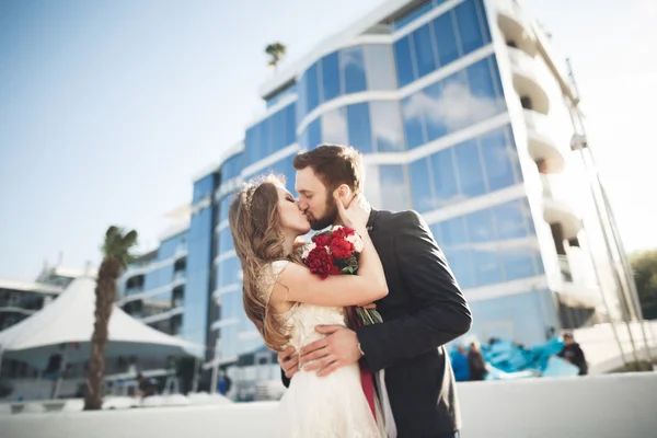 Elegante hermosa pareja posando cerca de edificio de vidrio moderno —  Fotos de Stock