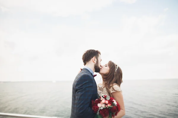 Casamento casal apenas andando na praia ao pôr do sol . — Fotografia de Stock