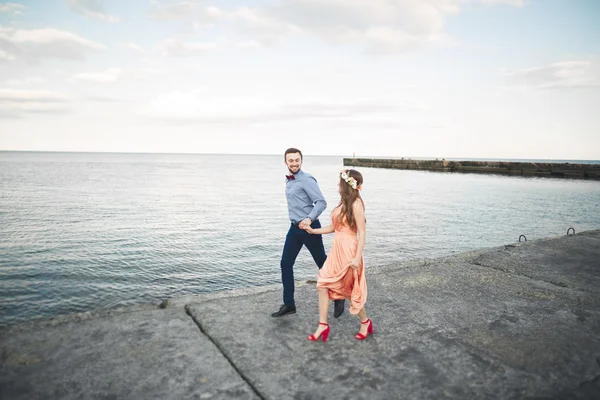 Hochzeitspaar, Braut, Bräutigam spazieren und posieren auf Seebrücke — Stockfoto