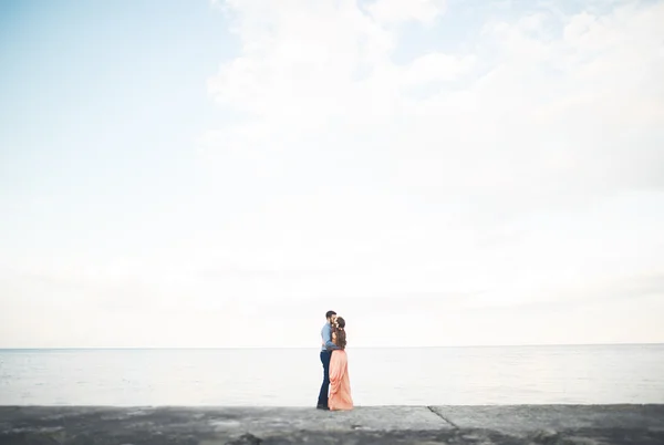 Hermosa pareja amorosa, orgullo con vestido largo caminando en el muelle — Foto de Stock