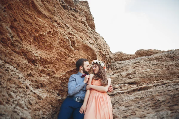 Romántica pareja amorosa caminando por la playa con rocas y piedras — Foto de Stock