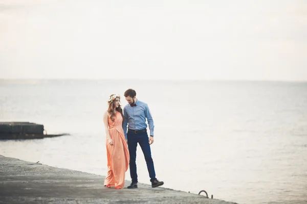 Casada pareja de boda de pie en un muelle sobre el mar —  Fotos de Stock