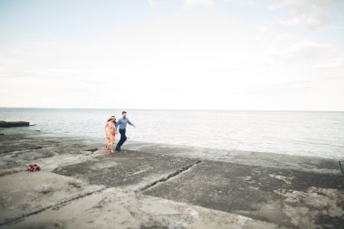 Güzel sevgi dolu çift, gurur iskelede yürüyüş uzun elbise ile