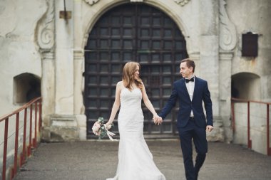 Mutlu düğün kaç sarılma ve birbirlerine arka plan eski kale üzerinde gülümseyen