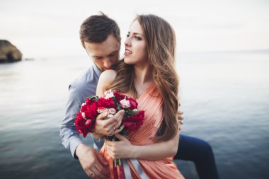 Mavi Denizi çevresinde büyük bir taş üzerinde oturan Düğün çifti