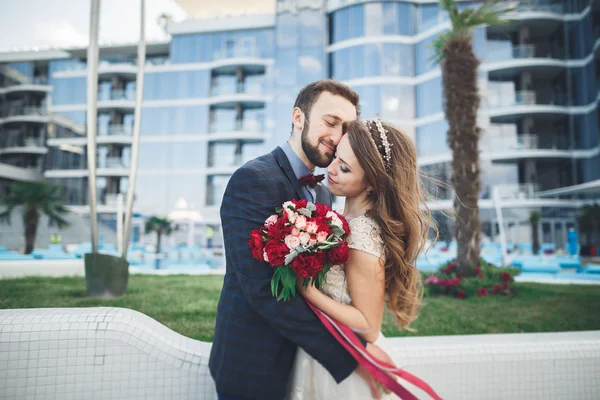 Elegant beautiful couple posing near modern glass building — Stock Photo, Image