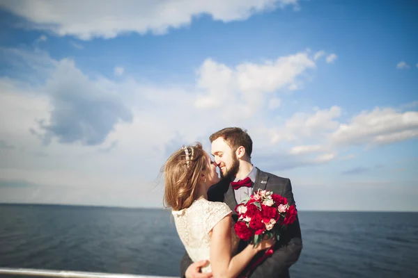 Pareja de recién casados caminando en la playa al atardecer . —  Fotos de Stock