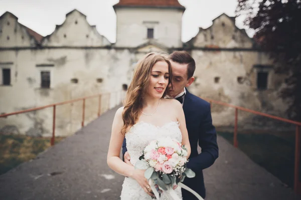 Bella coppia di sposi romantici che si abbracciano vicino al vecchio castello — Foto Stock