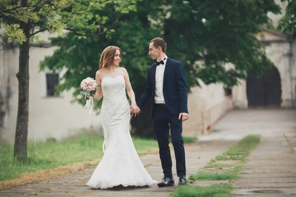 Para piękny szczęśliwy szykowny nowożeńców spaceru w parku w dniu ślubu z bukietem — Zdjęcie stockowe