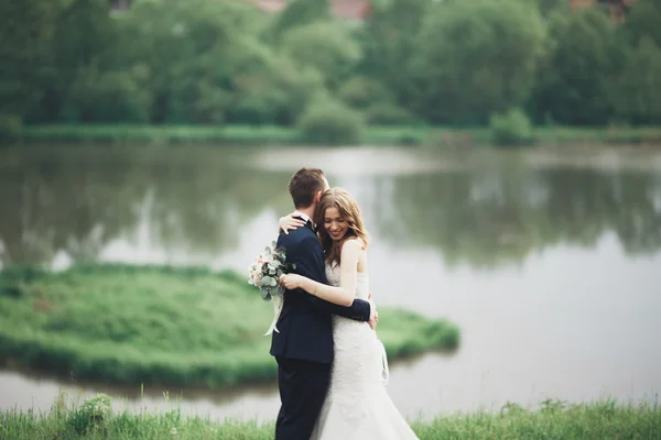 Romantické svatební pár, muž a žena, představuje v blízkosti krásného jezera — Stock fotografie