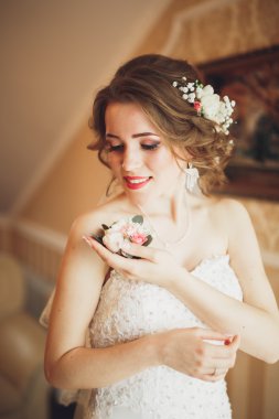 Beyaz elbiseli lüks gelin düğün törenine hazırlanırken poz veriyor.