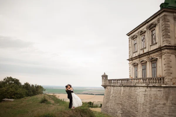 Beau couple de mariage romantique de jeunes mariés étreignant près du vieux château — Photo