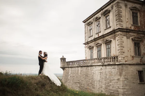 新婚快乐夫妇拥抱和亲吻在背景老城堡 — 图库照片