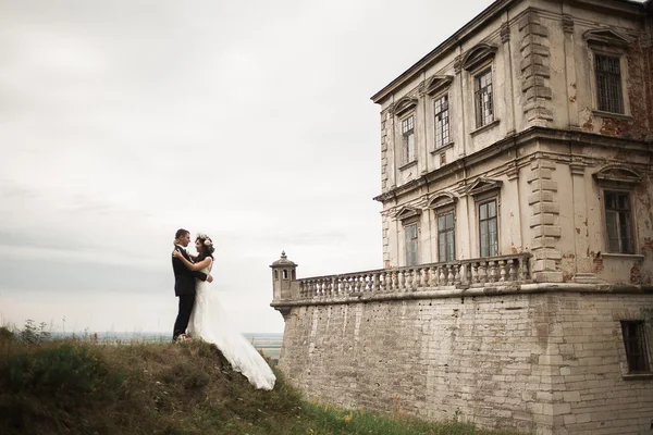 Felice matrimonio coppia abbracciare e baciare su sfondo vecchio castello — Foto Stock