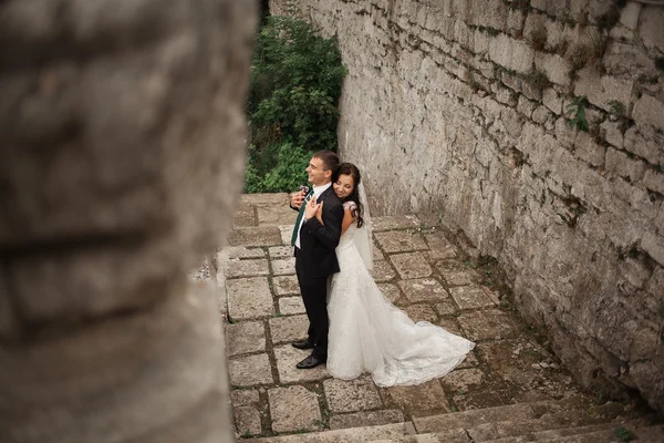 Feliz casamento casal abraçando e beijando no fundo velho castelo — Fotografia de Stock