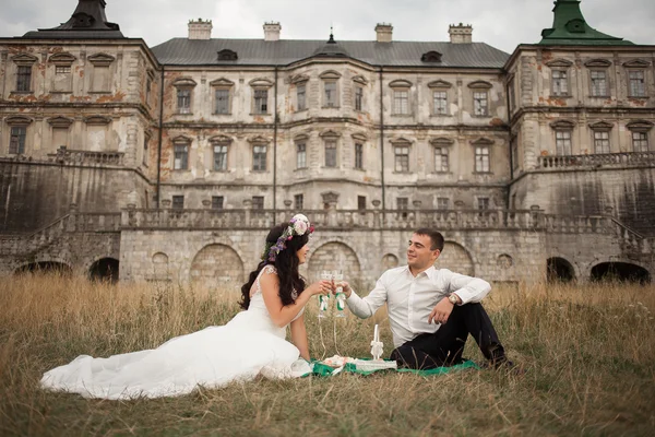 Šťastný Svatební pár objímat a líbat na pozadí starý hrad — Stock fotografie