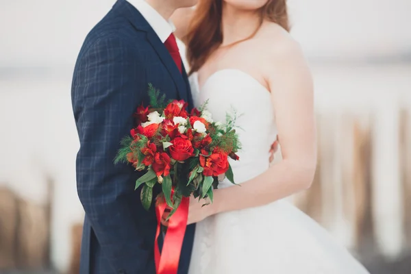 Gyönyörű esküvői csokor különböző elegáns virágokkal a menyasszony kezében — Stock Fotó