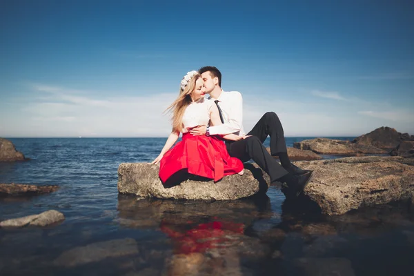 Deniz, mavi gökyüzü yakınındaki taş poz romantik sevgi dolu Çift — Stok fotoğraf