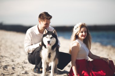 mutlu bir çift sahilde köpeklerle portresi