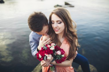 Mavi Denizi çevresinde büyük bir taş üzerinde oturan Düğün çifti