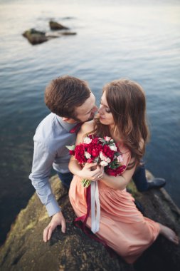 Mavi Denizi çevresinde büyük bir taş üzerinde oturan Düğün çifti