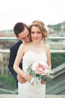 Mutlu düğün çift, Gelin, damat eski şehir manzarası ile öpüşme