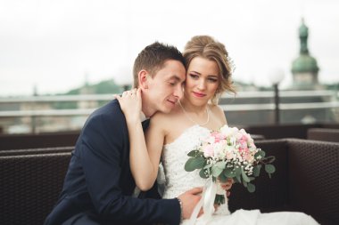 Mutlu düğün çift, Gelin, damat eski şehir manzarası ile öpüşme