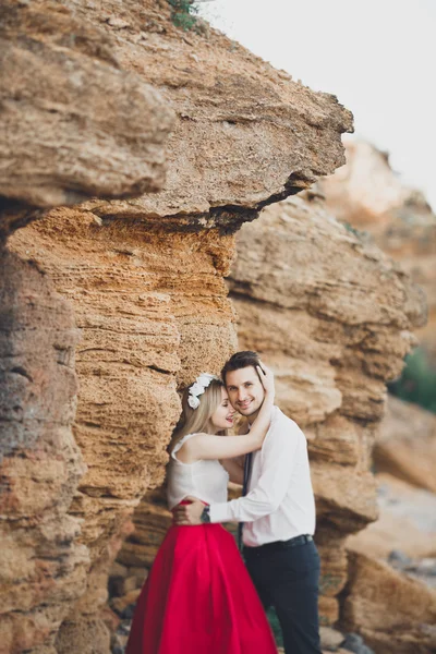 Romantica coppia amorevole a piedi sulla spiaggia con rocce e pietre — Foto Stock