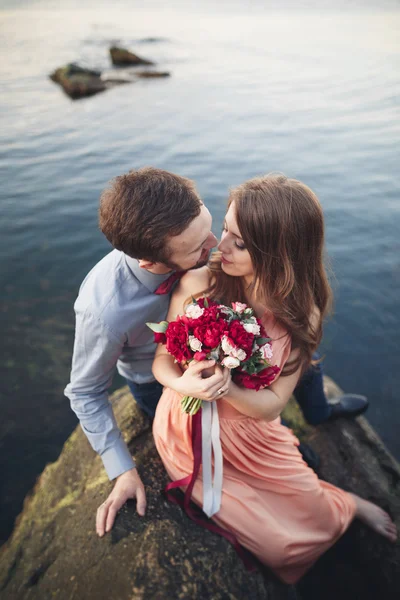 Mavi Denizi çevresinde büyük bir taş üzerinde oturan Düğün çifti