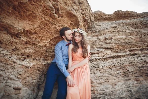 Romantica coppia amorevole a piedi sulla spiaggia con rocce e pietre — Foto Stock