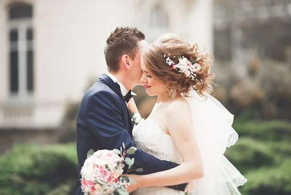 Wedding couple is standing and kissing in the streets of old city — Stock Photo, Image