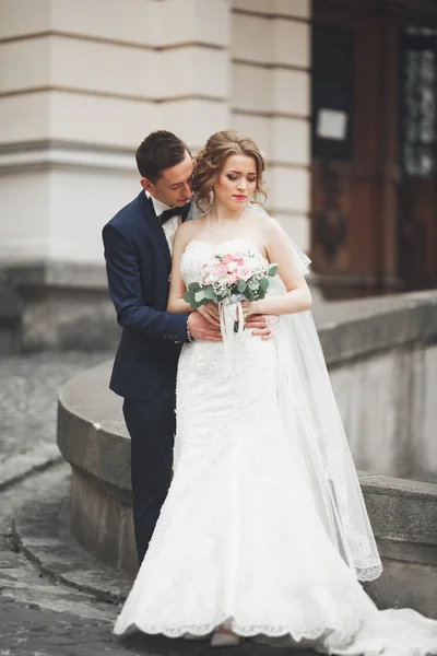 Wedding couple is standing and kissing in the streets of old city — Stock Photo, Image