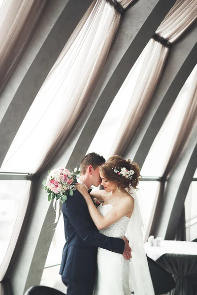 Casamento casal está de pé e beijando no hotel — Fotografia de Stock